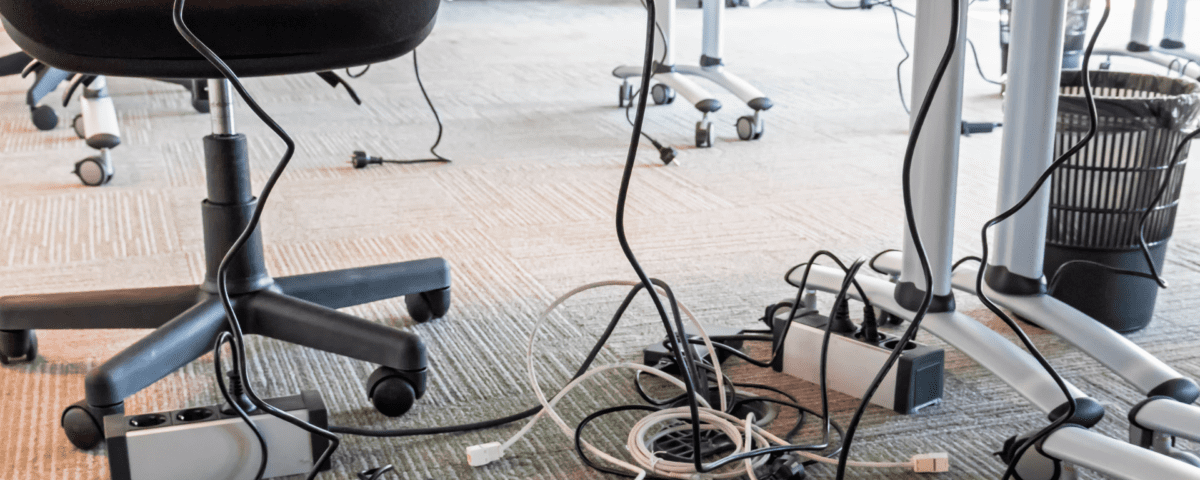 tangled cables in office space illustrating poor organization prior to teamwork training
