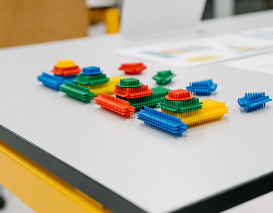 Colorful interlocking building blocks arranged on a table during a lean games workshop.