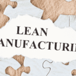 Torn paper with the words Lean Manufacturing on top of puzzle pieces — concept of 5S of Japanese methodology in production.