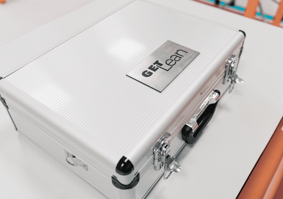 Silver case used in a lean production game training session, labeled "GET Lean."