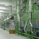 Modern production hall with green industrial machinery, illustrating lean methodology in practice.