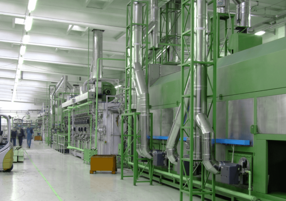 Modern production hall with green industrial machinery, illustrating lean methodology in practice.