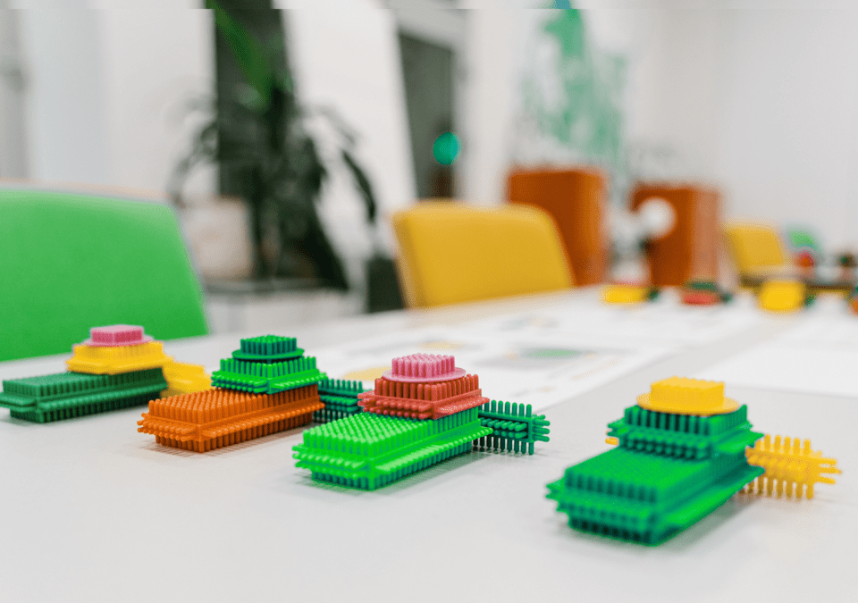 Top-down view of a training table set up for Effective Lean Games with instructions and modular builds.