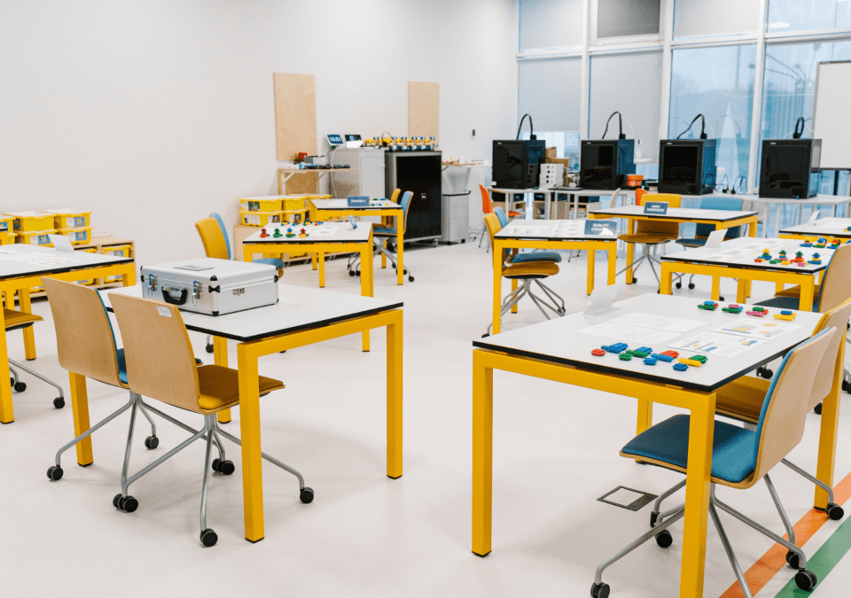 Lean Games for Training set up in a modern classroom with yellow tables and interactive materials.