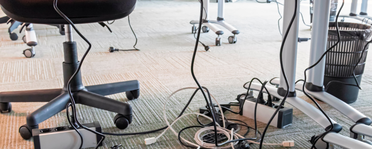 tangled cables in office space illustrating poor organization prior to teamwork training