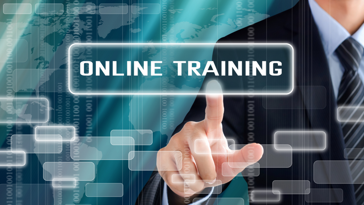 Businessman pressing a virtual button for “Online Training”, representing digital teamwork trainings.
