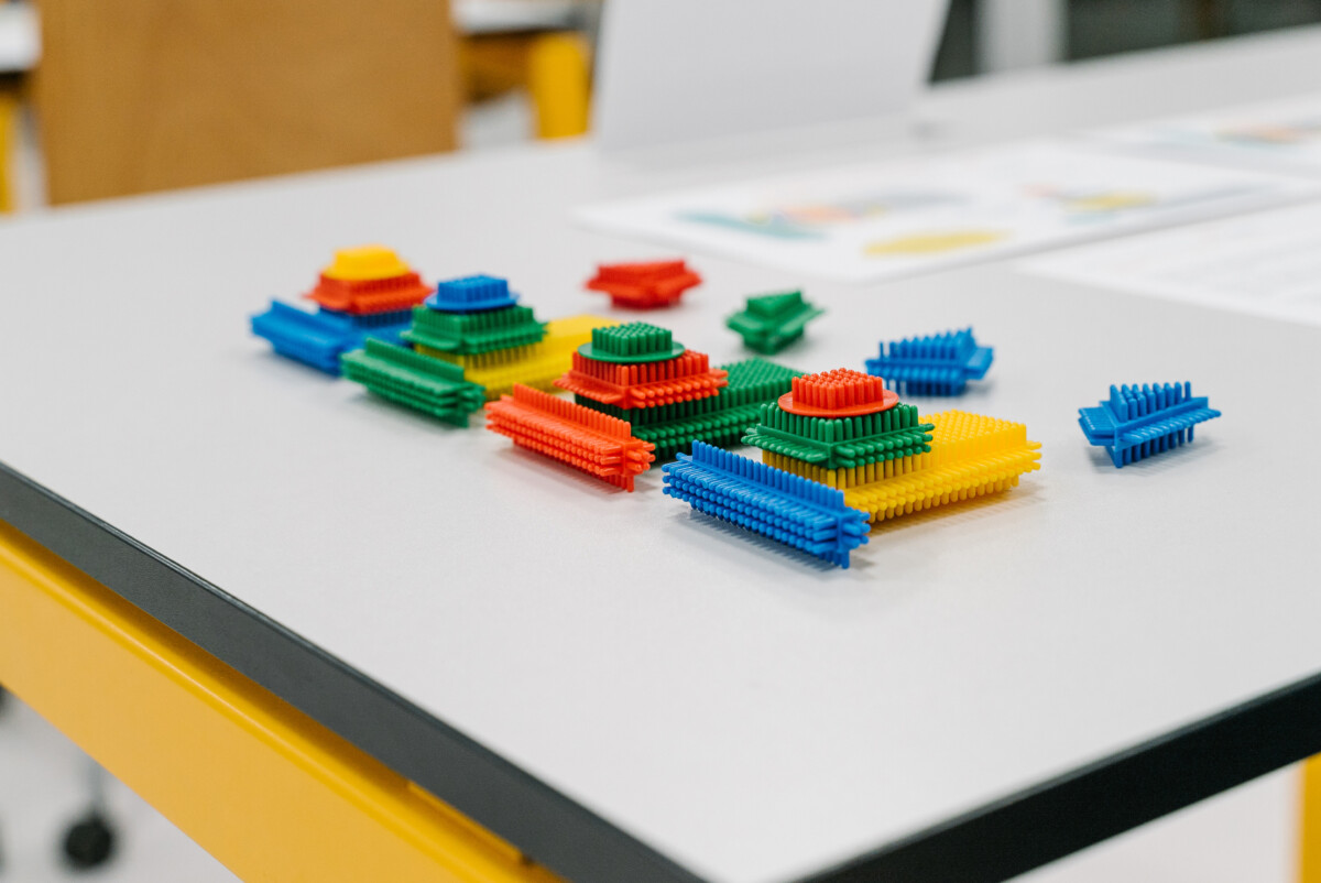Colorful interlocking building blocks arranged on a table during a lean games workshop.
