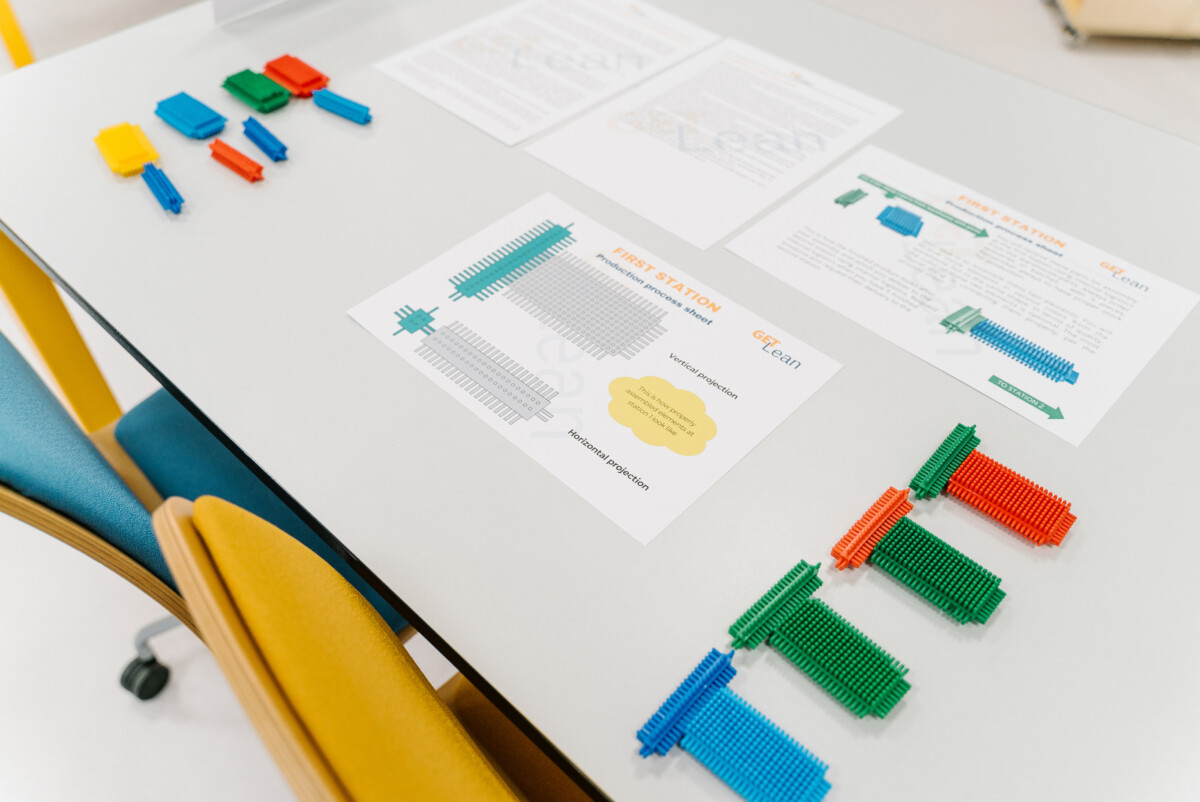 Lean Problem Solving Games setup with colorful blocks and process sheets at a training station. 