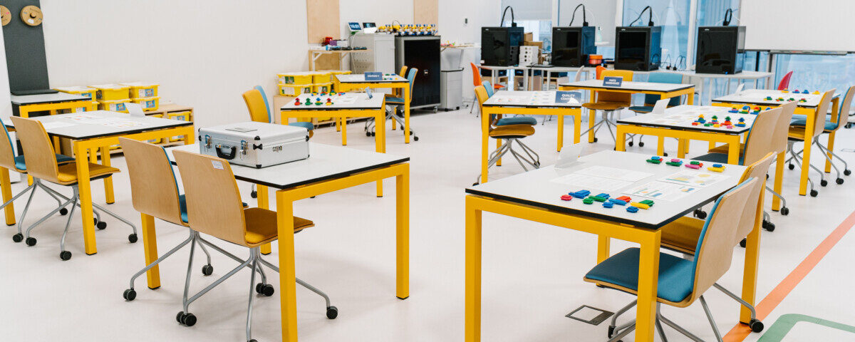 classroom setup with interactive workstations and materials prepared for a lean manufacturing game