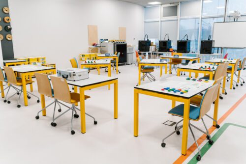 classroom setup with interactive workstations and materials prepared for a lean manufacturing game