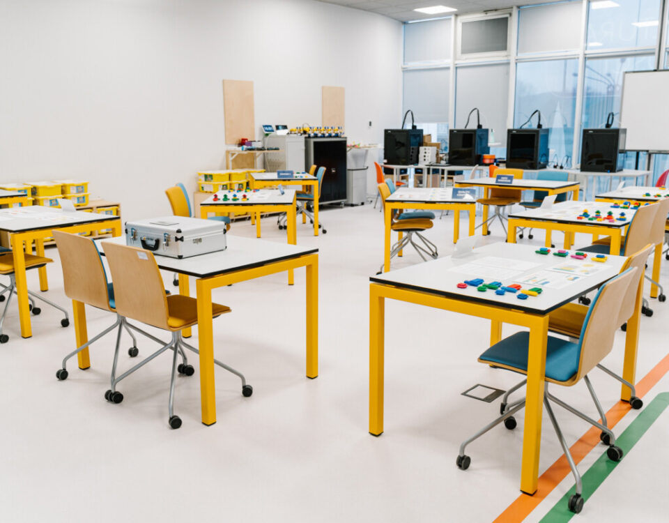 classroom setup with interactive workstations and materials prepared for a lean manufacturing game