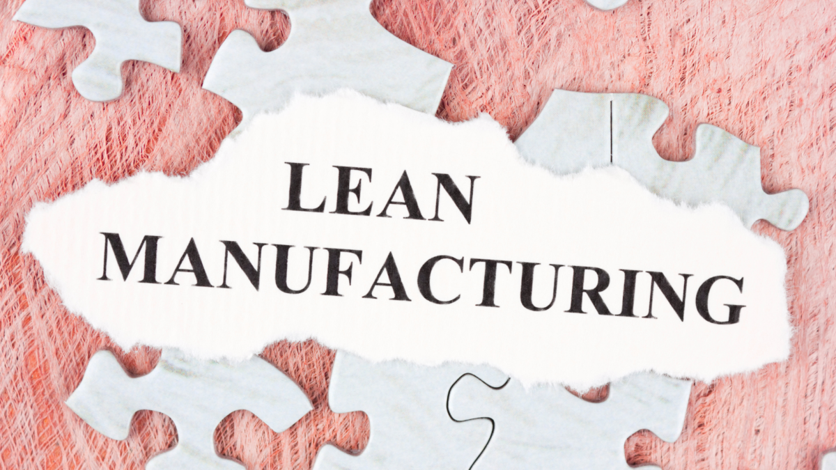Torn paper with the words "Lean Manufacturing" placed over puzzle pieces, symbolizing the use of 5S organization tools in efficient production systems.