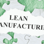 Lean Manufacturing concept on torn paper surrounded by puzzle pieces, symbolizing systematic approaches like 5S Checklists.