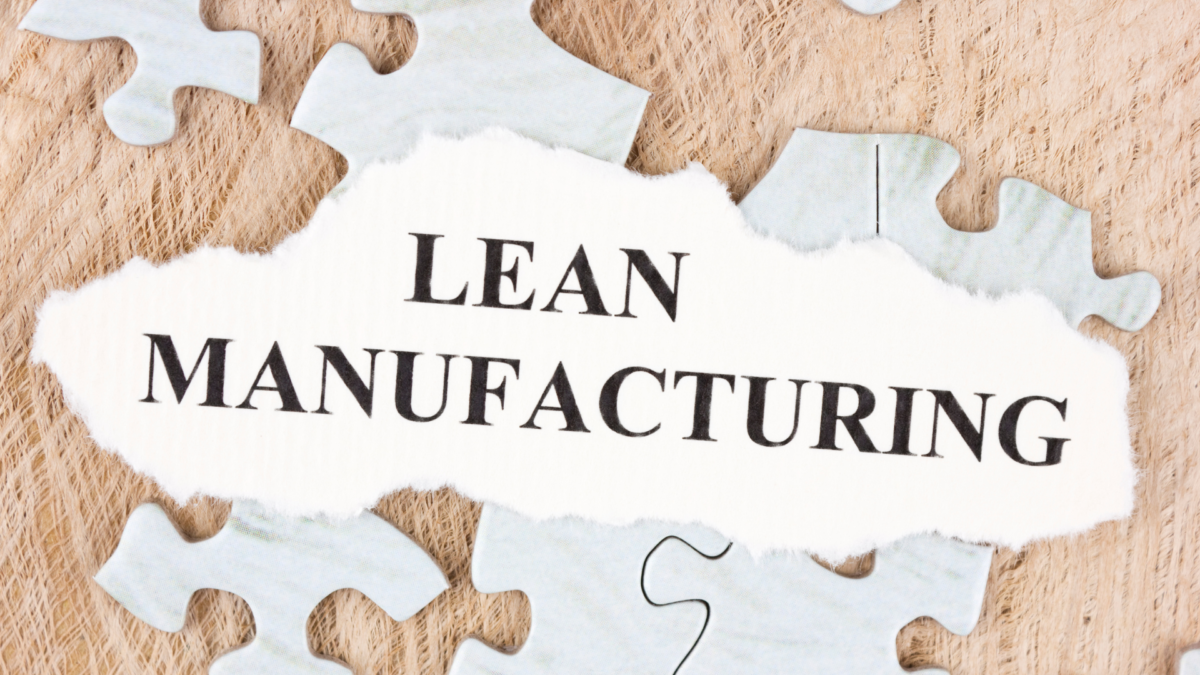 Torn paper with the words Lean Manufacturing on top of puzzle pieces — concept of 5S of Japanese methodology in production.