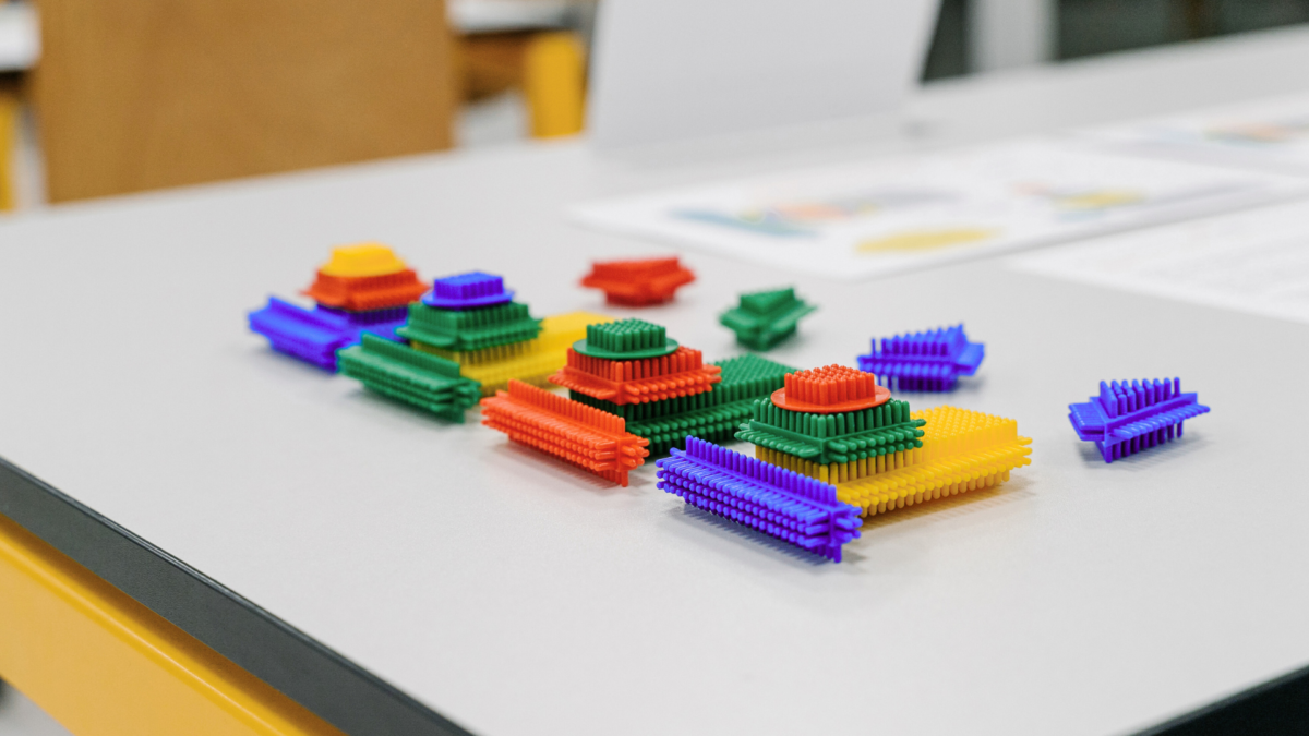 Colorful building blocks used during Lean Management Simulation Games to demonstrate production processes and waste reduction. 
