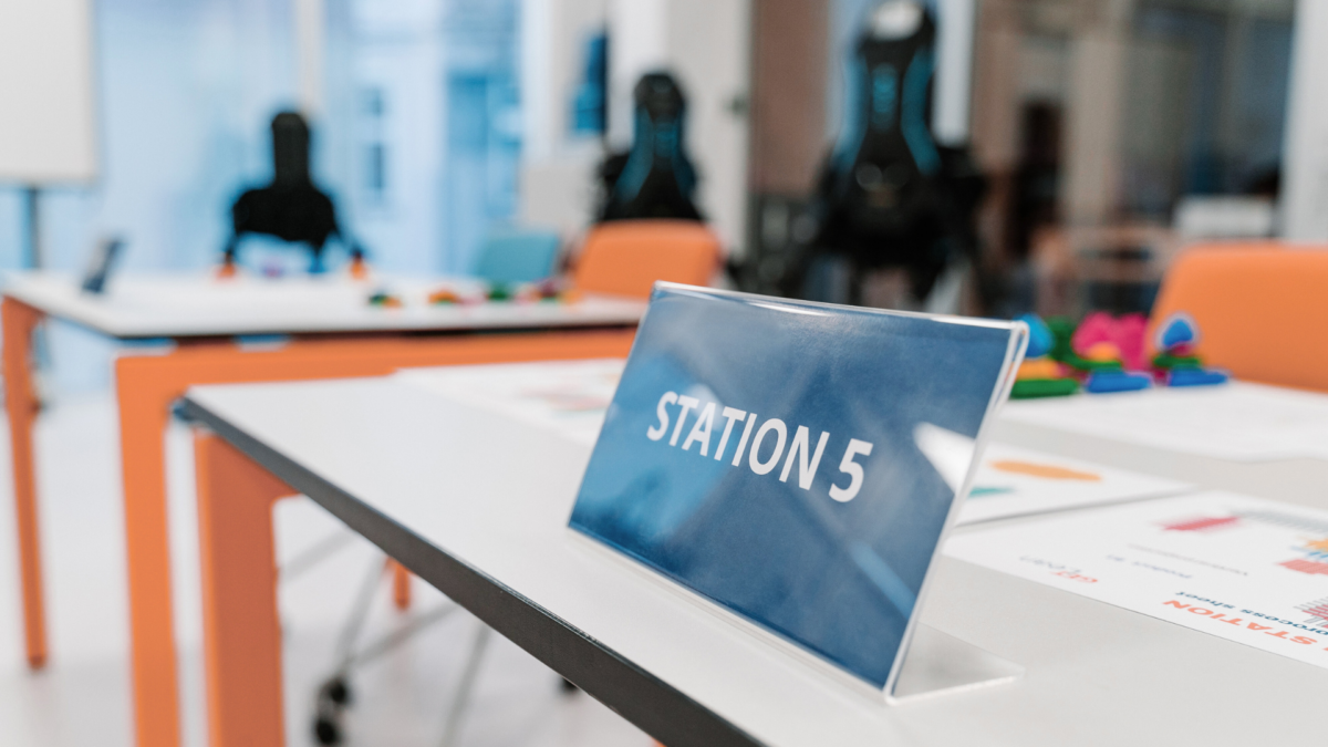 Station 5 setup for lean production game with colorful components on training tables. 