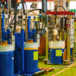 Automated dosing stations on blue drums in a clean 5S production cell organised around Lean Principles in Manufacturing.