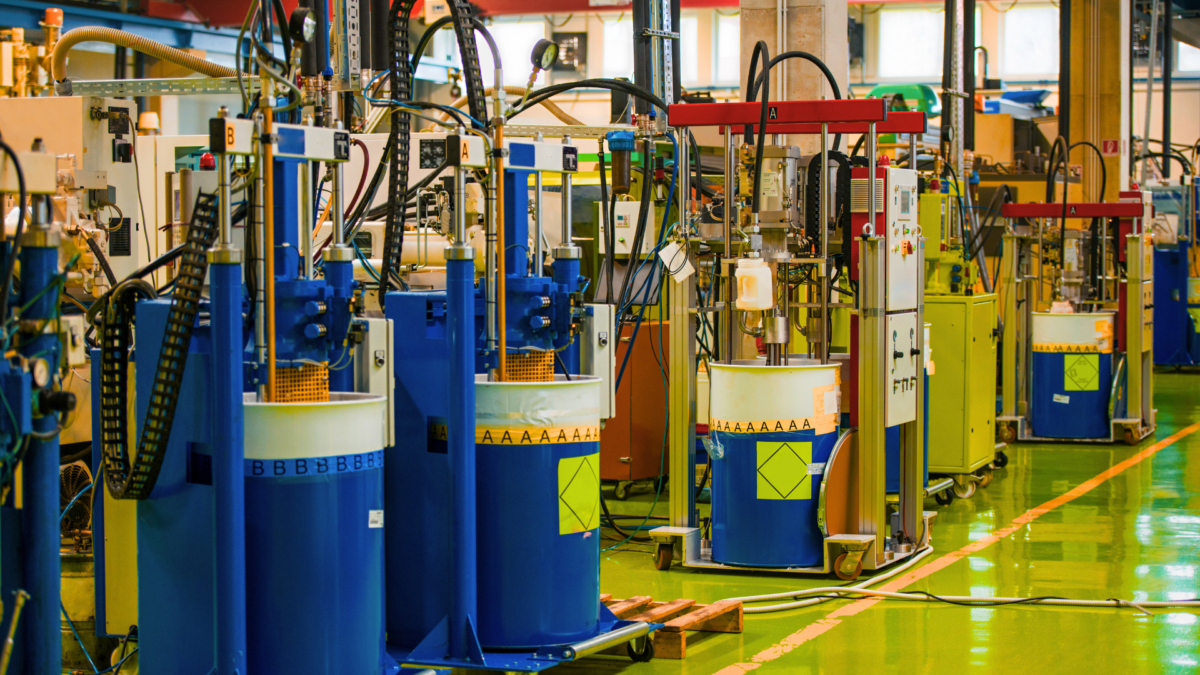 Automated dosing stations on blue drums in a clean 5S production cell organised around Lean Principles in Manufacturing.