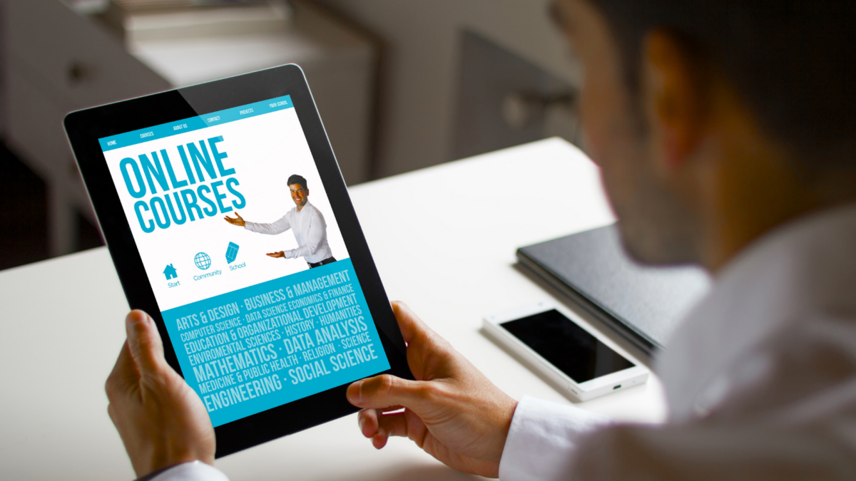 Professional viewing an online courses portal on a tablet for lean training manufacturing.