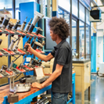 Worker applying Lean Process Improvement principles at a well-organized workstation in a manufacturing facility.