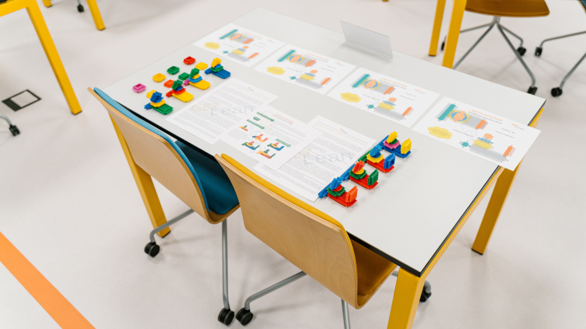 Top-down view of a training table set up for Effective Lean Games with instructions and modular builds.